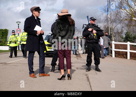 Cheltenham Festival, Gloucestershire, Großbritannien - Freitag, 16. März 2018 - Rennen goers Chat mit bewaffneten Polizisten am Cheltenham Racing Festival vor diesem Nachmittage Classic Gold Cup Rennen. Steven Mai/Alamy leben Nachrichten Stockfoto