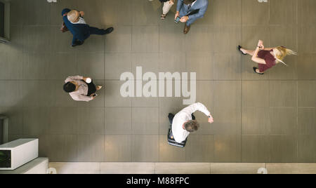 Blick von oben auf die Menschen zu Fuß durch einen Flur. Defokussierten Menschenmenge in einer Lobby. Stockfoto
