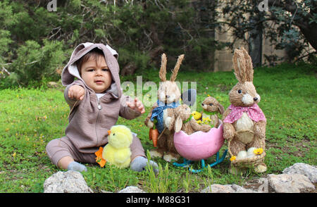 Ein Jahr baby Junge spielt die auf dem Gras in Kaninchen Anzug Stockfoto