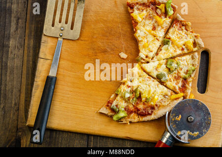 Scheiben pizza auf Holzbrett auf dunklen Tabelle, von oben. Stockfoto