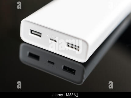 White Power Bank auf verspiegelte Oberfläche. Platz für Ihren Text. Stockfoto