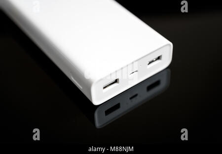 White Power Bank auf verspiegelte Oberfläche. Platz für Ihren Text. Stockfoto