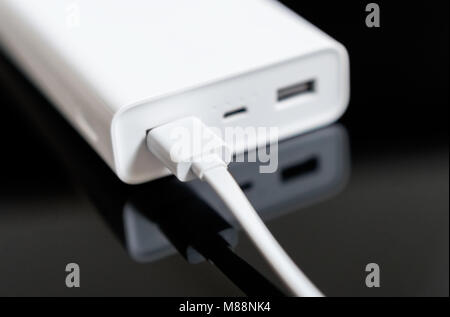 White Power Bank auf verspiegelte Oberfläche. Platz für Ihren Text. Stockfoto