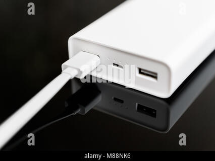 White Power Bank auf verspiegelte Oberfläche. Platz für Ihren Text. Stockfoto