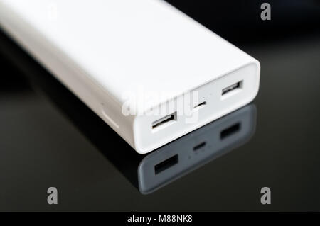 White Power Bank auf verspiegelte Oberfläche. Platz für Ihren Text. Stockfoto