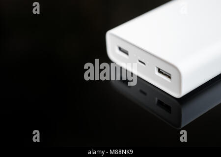 White Power Bank auf verspiegelte Oberfläche. Platz für Ihren Text. Stockfoto