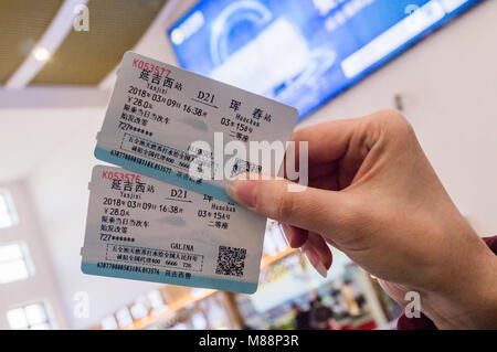 HUNCHUN, Jilin, China - 9. März 2018: Zwei Tickets in der Hand einer Frau für einen schnellen Zug von Yanjixi Stadt Hunchun Stadt. Szene am Yanjixi Eisenbahn Stockfoto