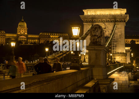 Twilight shot von Verkehr und leichte Wanderwege über die Kettenbrücke in Budapest. Die Lichter der Stadt sind und die Budaer Burg im Hintergrund Stockfoto