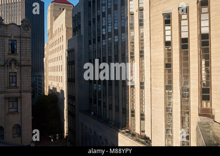 Modernes Gebäude im Schatten auf einer Straße im Geschäftsviertel der Stadt an einem sonnigen Tag Stockfoto