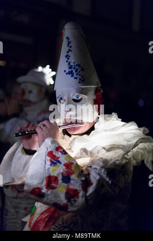 Schneidergasse, Basel, Schweiz - 19. Februar, 2018. Nahaufnahme von einem einzigen Karneval Teilnehmer tragen ein weißes Kostüm und spielen Piccolo Stockfoto