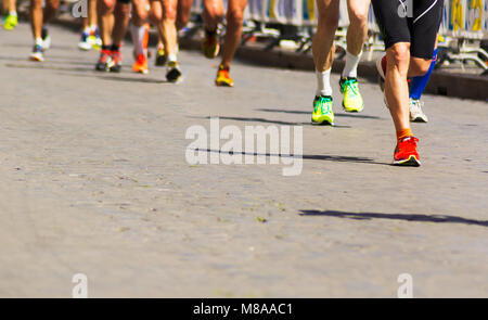 Detail einer Gruppe von Läufern während einer Stadt Marathon. Beine und Turnschuhe. Muskeln unter Stress. Sport Konzept Stockfoto