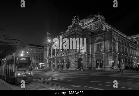 Weite Einstellung auf Verkehr, der vor der Wiener Oper am Opernring. Am frühen Abend im September getroffen, als sie die Lichter der Stadt sind auf kommenden Stockfoto