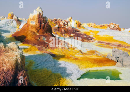 Gelbe Schwefelsäure Vulkane giftige Gas Wolken, Schwefelablagerungen weißen und grünen Farben Danakil Wüste, die Ferne Becken im Norden von Äthiopien. Stockfoto