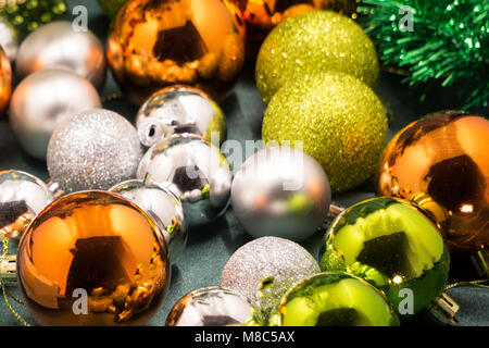 Bunte und lebendige Weihnachten arrangement. Nahaufnahme von Weihnachten goldene Kugeln mit Flitter und dekorativen Kranz. Stockfoto