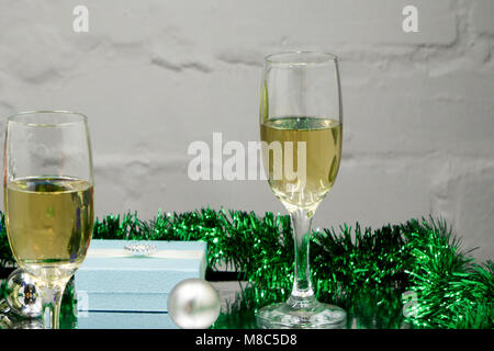 Zwei Gläser köstliche Champagner in der Nähe auf einem braunen Weihnachten Spielzeug Rot, Grün und Gold Farbe Stockfoto