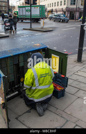 Ein BT oder Telekommunikation Ingenieur oder Techniker arbeiten in einer großen Exchange Box oder am Straßenrand Schaltschrank Kabel anschließen oder trennen. zur Festsetzung Stockfoto