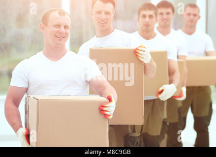 Team von Bauherren mit Boxen von Baustoffen Stockfoto