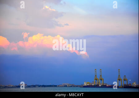 Blick über die Meerenge nach Butterworth Penang, Malaysia. Tropical Sunset Hintergrund mit gelben Krane gegen rosa Wolke Himmel Stockfoto