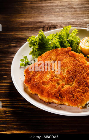 Gebratene Schweinekoteletts mit Salat Stockfoto