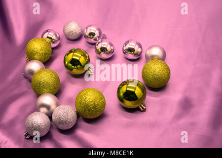 Das Herz ist mit Weihnachten Kugeln auf rosa Hintergrund gefüttert Stockfoto