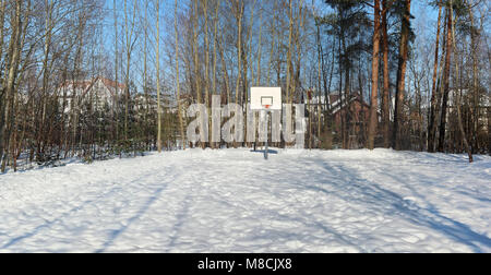 Einen leeren Basketballplatz in einem verschneiten Wald in der Nähe eines Europäischen Dorf. Panoramablick auf die Collage aus mehreren Outdoor Winter sonniger Tag Fotos Stockfoto