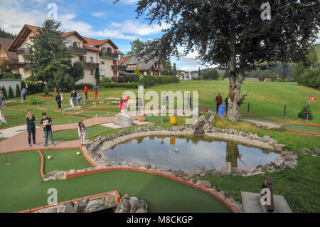 Familien setzen auf ein Mini Golf oder das Setzen des Kurses Stockfoto