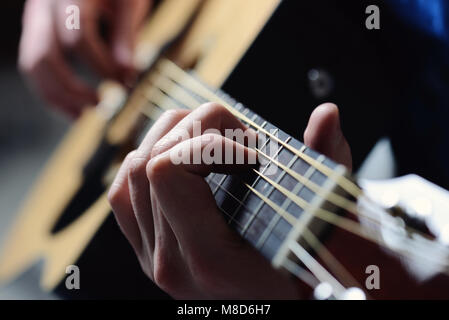 Des Menschen Hände spielen akustische Gitarre Stockfoto