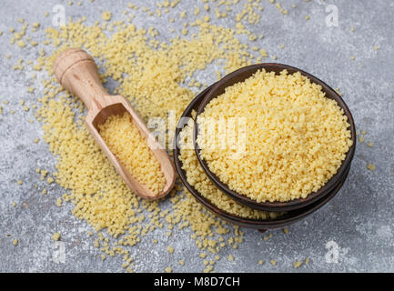 Raw organic Couscous in eine Schüssel auf dem Tisch. Selektiver Fokus Stockfoto
