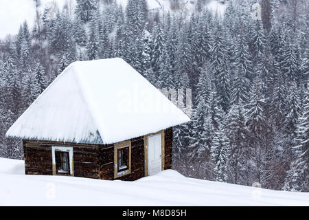 Kleine Holzhäuser auf rumänischen Berge im Winter mit viel Schnee Stockfoto