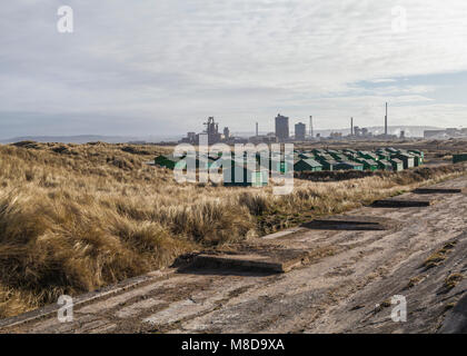 Die fishermens Hütten am South Gare, Redcar, England, UK mit der ehemaligen SSI Stahlwerk im Hintergrund Stockfoto