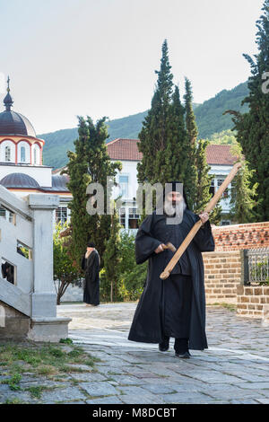 Einen orthodoxen Mönch klingt der Abend Gebet durch Anschlagen einer hölzernen semantron an der Skete von Saint Andrew bei Karyes auf der Halbinsel Athos, Mace Stockfoto