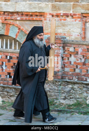 Einen orthodoxen Mönch klingt der Abend Gebet durch Anschlagen einer hölzernen semantron an der Skete von Saint Andrew bei Karyes auf der Halbinsel Athos, Mace Stockfoto