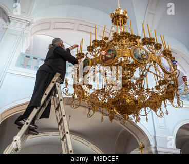 Ein Mönch Kerzen ersetzen in einem Leuchter in der Kirche des Heiligen Andreas Skete in Karyes auf der Halbinsel Athos, Mazedonien, Nordgriechenland Stockfoto