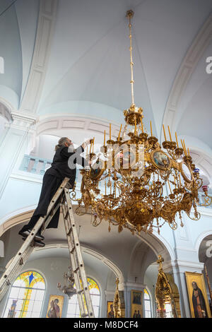 Ein Mönch Kerzen ersetzen in einem Leuchter in der Kirche des Heiligen Andreas Skete in Karyes auf der Halbinsel Athos, Mazedonien, Nordgriechenland Stockfoto