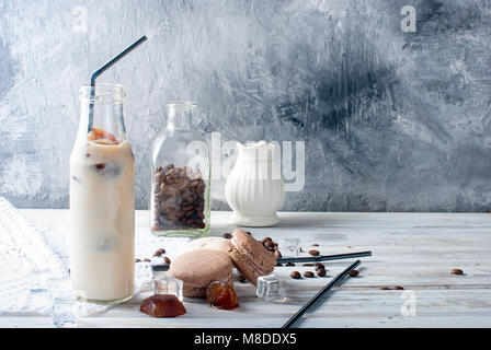 Kaffee Eis in der Flasche, Makronen,, Stücke von Schokolade und Kaffee Bohnen auf einem dunklen Tabelle Stockfoto