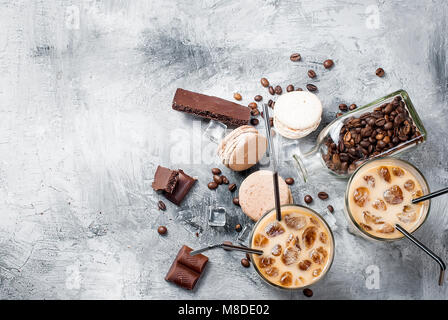 Kaffee Eis in Glas, Makronen,, Stücke von Schokolade und Kaffee Bohnen auf einem grauen Tabelle, Ansicht von oben, kopieren Raum Stockfoto