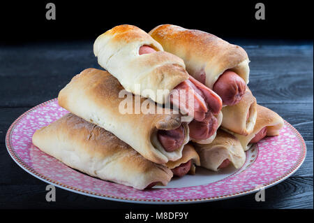 Wurst in einem Teig auf einer Platte. Stockfoto