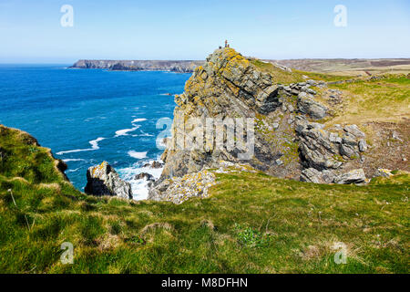 Menschen, die auf einem Felsvorsprung auf der Lizard Halbinsel, Cornwall, South West England, Großbritannien Stockfoto