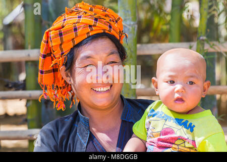 Burmesische Frau, die im Februar im Dorf Indein, Inle Lake, Shan State, Myanmar (Burma), Asien ihr Baby trägt Stockfoto