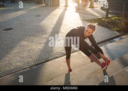 Junge Frau aufwärmen, Stretching Beine Stockfoto