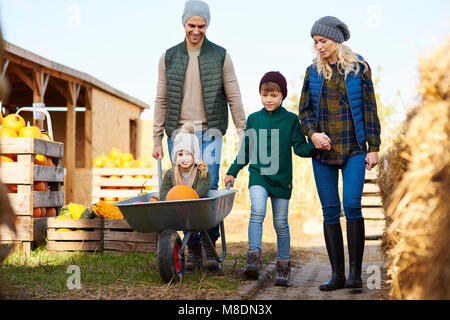 Paar mit Sohn und Tochter in der Schubkarre bei Pumpkin Patch. Stockfoto