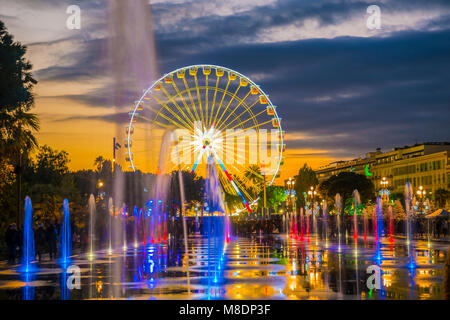 Springbrunnen und Riesenrad in der Dämmerung in Nizza in Provence-Alpes-Côte d'Azur, Frankreich Stockfoto