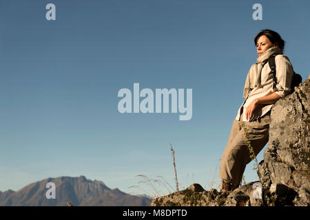 Frau entspannen Sie sich auf einem Berg mit alpinen Lago Maggiore im Hintergrund, im Tessin, Schweiz Stockfoto