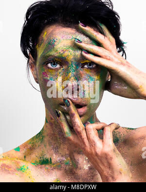 Studio Porträt der jungen Frau mit glitzerndem mehrfarbige Pulver auf dem Gesicht Stockfoto
