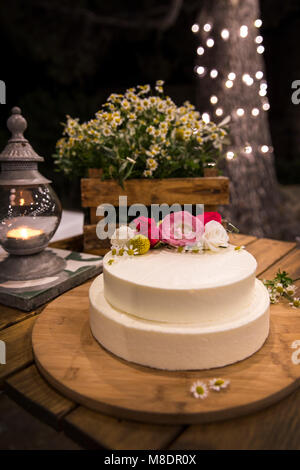 Hochzeitstorte mit Blumen auf holzbrett eingerichtet Stockfoto