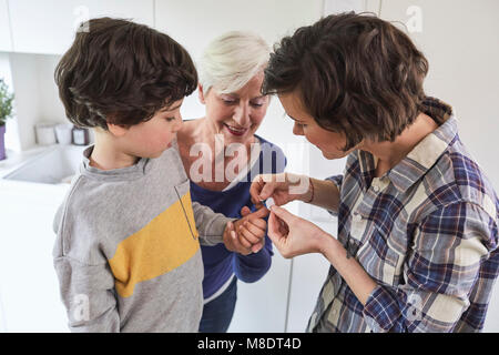 Mutter, Putz auf, der Sohn von Finger-, Hand der Großmutter mit Enkel Stockfoto
