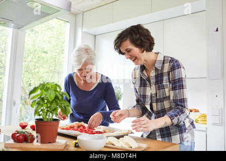 Mutter und erwachsene Tochter zu Hause, das Vorbereiten der Nahrung zusammen Stockfoto