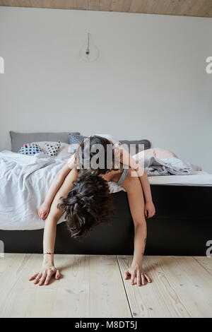 Mutter und Tochter auf dem Bett liegend, die Tochter auf die Mutter zurück Stockfoto