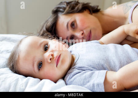 Portrait von Mutter und Tochter, entspannend auf Bett Stockfoto