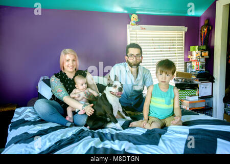 Familie auf dem Bett im Schlafzimmer Stockfoto